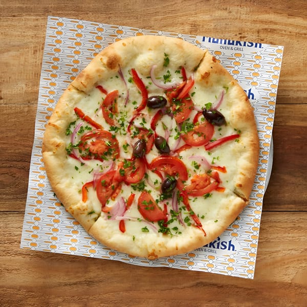 Manakish Oven & Grill's Mediterranean pizza with tomatoes, red onions, olives, and parsley.