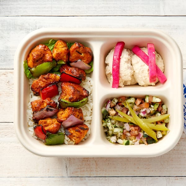Manakish Oven & Grill's Mediterranean chicken shish tawook with rice, hummus, and salad.