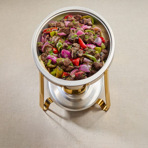 Mediterranean beef and vegetable dish with red onions, green and red peppers in a silver chafing dish.